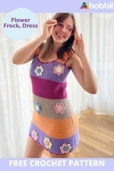 a woman in a colorful crochet dress is holding her hands up to her face