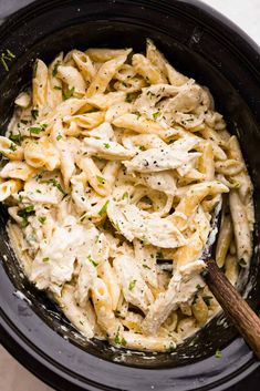 pasta with chicken and parsley in a slow cooker, ready to be cooked