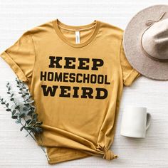 Keep Homeschool Weird Shirt, Homeschool Shirt, Homeschooling Mom, homeschoolers, Back to School Shirt, Mother's Day Gift WASHING INSTRUCTIONS-Printed apparel can be machine-washed cold, inside-out on a gentle cycle with a mild detergent and like colors. Use non-chlorine bleach only when necessary. You shouldn't use any fabric softeners or dry-clean the items. DTG-printed apparel can be tumble-dried on a low cycle, but hang-dry works best. When it comes to ironing, use cool iron inside-out. Don't School Slogan T-shirt In Cotton, College Fun School Spirit T-shirt With Funny Text, Pre-shrunk College Style Tops For School, Funny Cotton T-shirt For School, College Tops With Funny Text For School Spirit, Cotton School Spirit T-shirt For School, College Tops With Funny Text And School Spirit, Yellow Letter Print Top For School, Funny Cotton College T-shirt