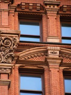 the corner of an old brick building with ornate carvings