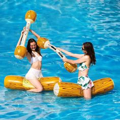 two women in swimsuits are playing with an inflatable raft