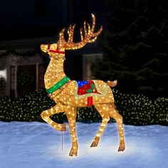 a lighted reindeer standing in the snow