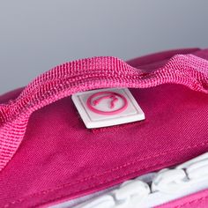 a close up of a pink bag with a tag on it