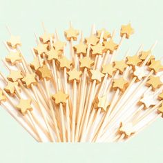 a bunch of gold stars on top of toothpicks