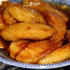 a blue and white bowl filled with fried bananas