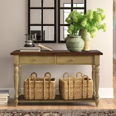 a wooden table with baskets on it next to a mirror