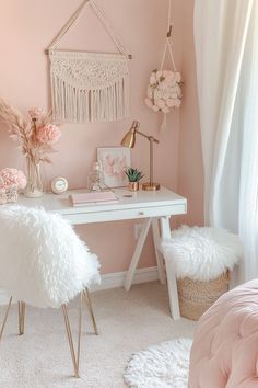 a bedroom with pink walls, white furniture and flowers on the desk in front of it