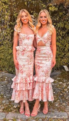 two women standing next to each other in dresses