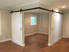 an empty room with sliding doors and hard wood flooring