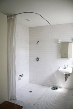 a bathroom with a sink, mirror and shower head in it's center wall