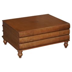 a brown leather ottoman sitting on top of a wooden table