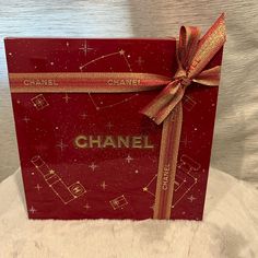 a red box with a gold ribbon on it and the word chanel written in gold