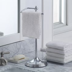 a bathroom sink with towels and soap dispenser