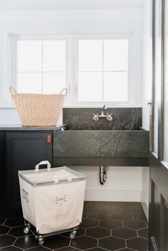 a white basket sitting on top of a counter next to a bathtub and sink