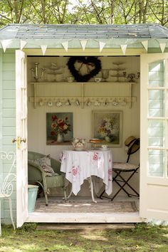 a table and chairs are set up in the back of a shed with an awning