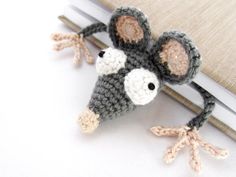 a crocheted mouse sitting on top of a book