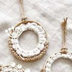 three ornaments are hanging on a white cloth