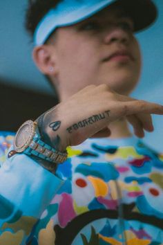 a person with a wrist tattoo pointing at something