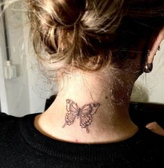 a woman's neck with a butterfly tattoo on the back of her left neck