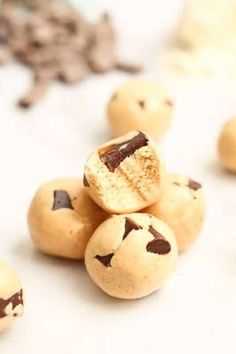 chocolate chip cookies sitting on top of each other next to cookie doughnuts in the background