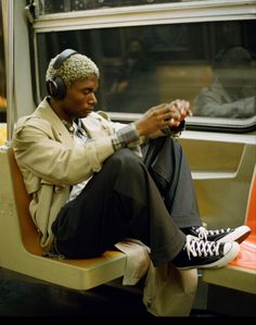 a man wearing headphones sitting on a train