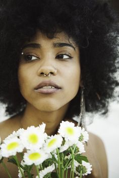 a close up of a person with flowers in front of her face