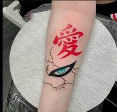 a person with a tattoo on their arm that has an evil eye and chinese writing