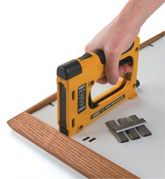 a person is using a stapler to attach wood planks on a white background