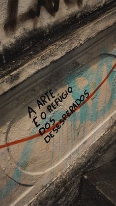 graffiti on the side of a building with words written in spanish and latin characters painted on it