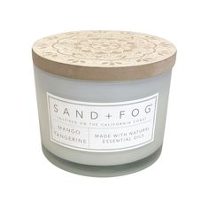 a candle that is sitting in front of a white background with the words sand and fog on