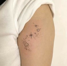 a woman's arm with stars and hearts tattoo on the left side of her right arm