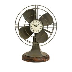 a metal clock sitting on top of a wooden stand next to a small table fan