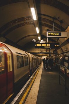 a subway station with people walking on the platform