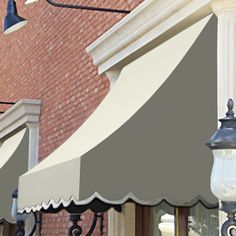 an awning on the side of a building next to a street light and lamp post