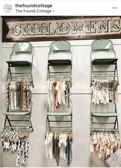 several shelves with clothes hanging on them in a store