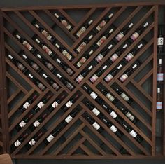 a wooden wine rack with many bottles in it