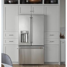 a stainless steel refrigerator in a white kitchen