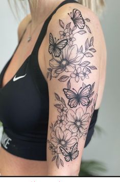 a woman's arm with black and white flowers on the left side of her body