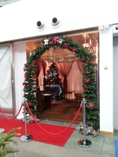 a red carpeted entrance to a room decorated with christmas wreaths and garlandes