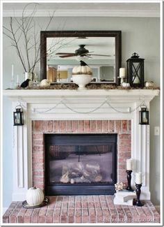 a fireplace with candles and decorations on top