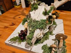 a wooden table topped with an animal head covered in moss