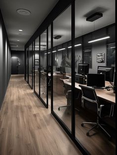 an office with glass walls and wooden floors