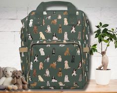 a green backpack with dogs on it next to stuffed animals and a potted plant