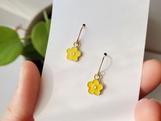 "How cute are these sunshine yellow daisy flower earrings? The yellow enamel and gold charm brightens up any outfit. These small hypoallergenic earrings work for every aesthetic. Simple, Cottage, Boho - anyone? :)  Handmade in the rainy NW, from these materials: 14k gold fill ear wire   *hypoallergenic + safe for sensitive skin gold plated enamel daisy CARE TIPS: These beauties are are low-maintenance but if the ear wire  loses shine, gently buff with a jewelry specific polishing cloth. Use a dry, cotton cloth on the enamel charm. BEST PRACTICE: Put the jewels on last (after shower, hair, makeup).  Avoiding / Limiting exposure to beauty products or harsh environments will extend the life of these pieces. *If you have questions, feel free to ask! Measurement: approx. .75\" More Enamel Earri Gold Flower Charm Earrings For Summer, Everyday Gold Enamel Earrings, Gold Enamel Earrings With Flower Charm, Gold Earrings With Flower Charm In Enamel, Gold Earrings With Flower Charm And Enamel, Cute Gold Flower Charm Earrings, Cute Gold Flower-shaped Earrings, Gold Enamel Flower Earrings For Gift, Yellow Flower Charm Earrings For Spring