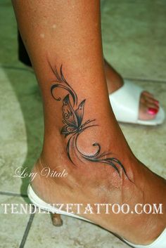 a woman's foot with a butterfly tattoo on it