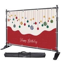 a merry christmas banner with ornaments hanging from it's sides and a black bag next to it