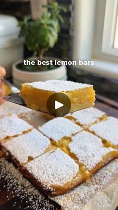 someone is cutting into some lemon bars with a knife