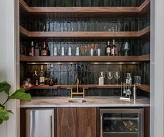 a kitchen with wine glasses and bottles on the shelves