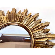 a gold sunburst mirror sitting on top of a table