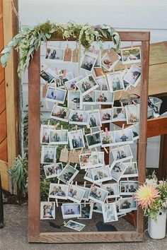 a wooden frame filled with photos and flowers on top of a table next to a potted plant